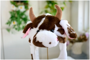 Detailed view of plush cow hat with soft brown spots and fluffy faux fur texture