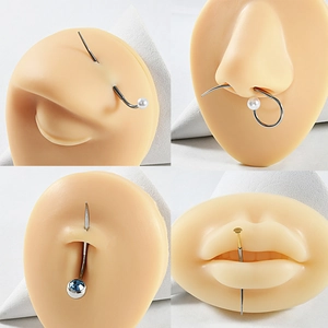 Detail view of 316L stainless steel body piercing jewelry on silicone anatomical models