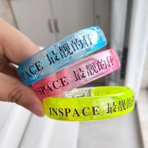 Close-up of blue, pink and yellow LED silicone wristbands with INSPACE cool typography