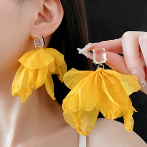Detail von gelben Stoffblumen-Ohrringen mit quadratischem Kristall und Goldakzenten