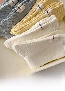 Detail of ribbed cotton socks in pastel tones with side label and soft texture