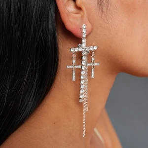 Silver cross drop earrings with sparkling crystals and long tassels on model