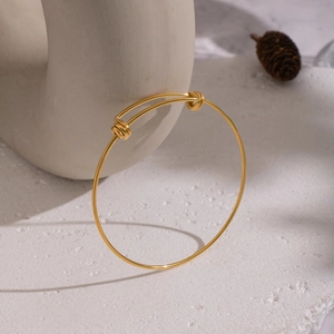 Minimalist 18K gold plated stainless steel adjustable knot bangle on white stone surface