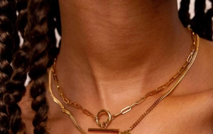 Detail of layered gold-plated stainless steel necklaces with OT toggle clasp on model