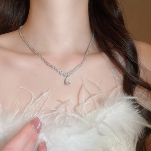 Detailed view of teardrop zircon necklace worn by a model in elegant white attire