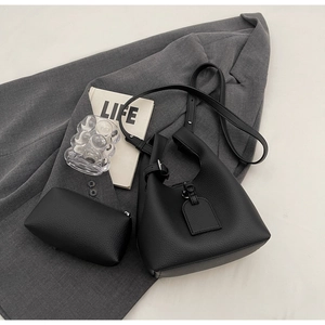 Detail of black lychee grain leather bucket bag set with matching inner pouch