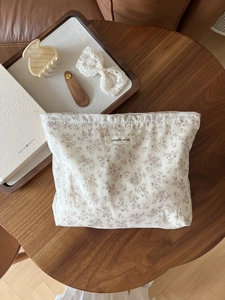 Macro view of cotton floral storage pouch with 'simple wish' label on wooden table