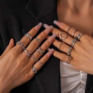 Close-up of 16-piece silver geometric ring set with chain and spiral designs on hands