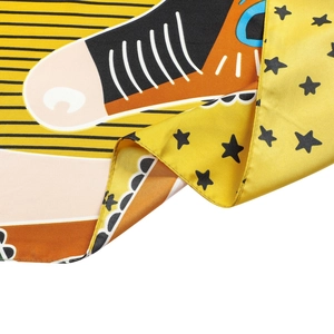 Detail view of the colorful plaid silk scarf featuring orange stripes and black star patterns