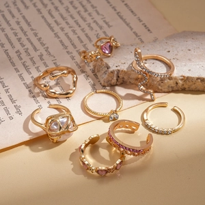 Detailed close-up of 8-piece gold bohemian ring set with pink hearts and snake accents