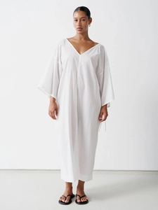 Detail of loose V-neck cotton dress featuring drop shoulders and light breathable fabric