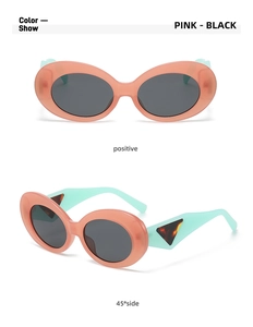 Detail view of oval cat-eye sunglasses with pink frames and green temples