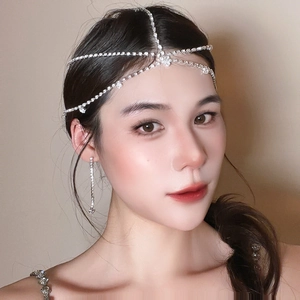Détail de la coiffe de mariée élégante et des boucles d'oreilles à pompons en strass argentés