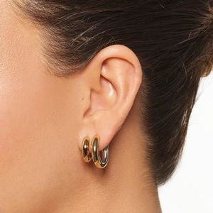 Luxurious S925 sterling silver gold hoop earrings worn by a model in a close-up side view