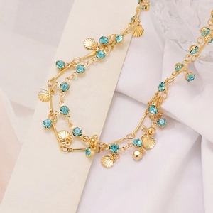 Detail of gold shell pendants and blue crystals on bohemian layered necklace
