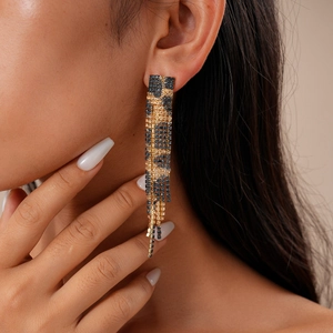 Close-up of model wearing leopard print rhinestone tassel earrings in gold and black