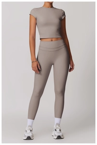 Set da yoga grigio con crop top aderente e leggings sportivi a vita alta in studio