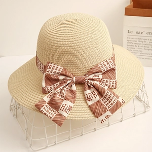 Elegant wide brim straw hat with bow ribbon and Always Happy print for beach sun protection
