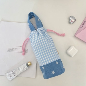 Detail of blue plaid water bottle bag with star patterns and pink drawstring cord