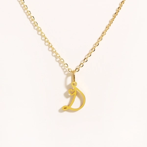 Close-up of golden stainless steel D-letter pendant necklace with a tiny heart detail