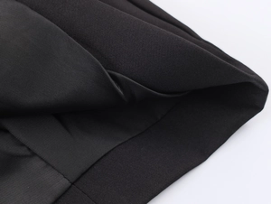 Detailed shot showing the high-quality black fabric texture and fine stitching on the blazer
