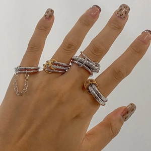 Détail de bagues superposées en acier inoxydable avec perles et zircons portées par un mannequin