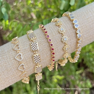 Detail of five 18K gold plated bracelets with cubic zirconia on a rustic linen display