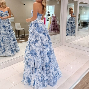Elegant strapless blue and white floral tiered maxi gown with a corset-style bodice