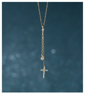 Detail of golden S925 silver cross pendant necklace with round diamonds and long tassels
