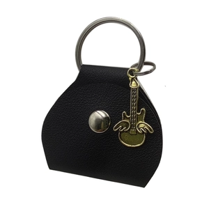Close-up of black leather guitar pick pouch with metallic snap and golden guitar pendant