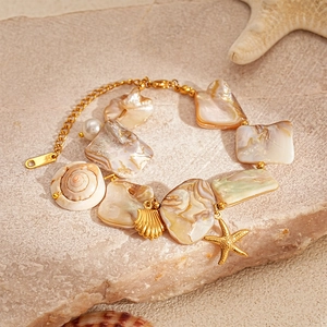 Detail of beach style necklace featuring natural shells, gold starfish and pearls