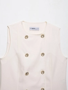 Detail of cream sleeveless vest with golden double-breasted buttons and woven texture
