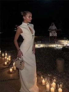 Detailed view of cutout neckline with metal accents on a sleek white sleeveless dress
