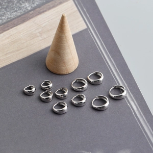 Macro shot of multiple sizes S925 sterling silver hoop earrings on wooden display
