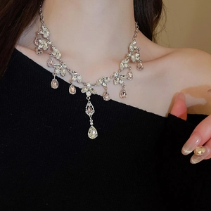 Detailed close-up of a silver tassel necklace featuring waterdrop and leaf crystals