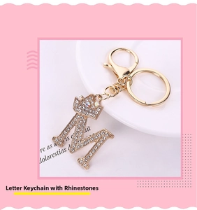 Macro shot of sparkling crystal letter M keychain with a gold crown and lobster clasp detail