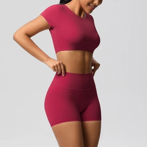 Détail de l'ensemble de yoga rose rouge avec crop top et short de sport à taille haute