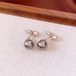 Detail of double pearl earrings with grey and champagne pink beads on gold hardware