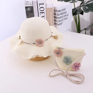 Detail of child straw hat and bag set with delicate floral fabric decorations