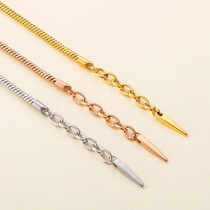 Detail of snake bone bracelets in gold, rose gold and silver with teardrop pendants