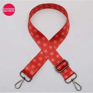 Detail view of red polka dot bag strap with adjustable gunmetal swivel snap hooks