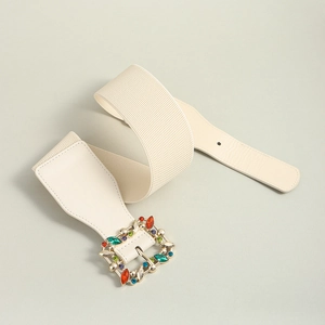 Close-up of white elastic belt featuring a gold buckle with colorful rhinestones