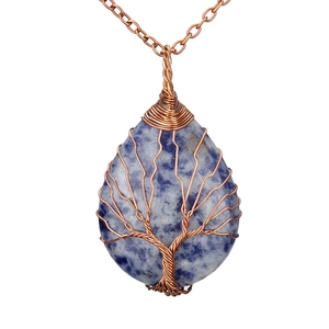 Macro shot of sodalite crystal pendant with copper wire wrapped tree of life detail
