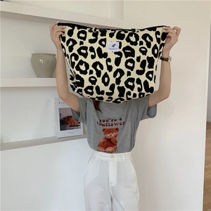 Close-up of leopard print canvas tote bag with a minimalist white brand label tag