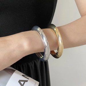 Détail de joncs métalliques minimalistes en or et argent avec un design tubulaire poli