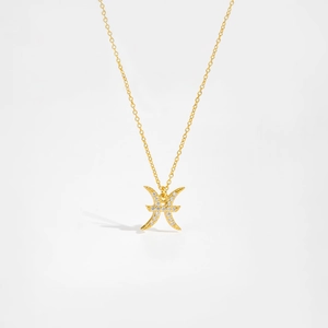 Detailed macro view of the golden Pisces zodiac necklace pendant with sparkling zircon stones