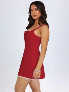 Dettaglio laterale di un mini abito rosso con pizzo bianco e vestibilità slim