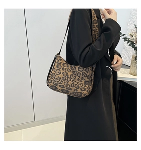 Detailed view of the leopard print shoulder bag worn by model in a soft indoor setting
