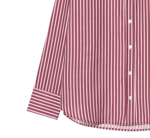 Detail of red vertical striped poplin shirt with white buttons and curved hem line
