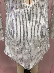 Detalle del minivestido blanco con flecos de lentejuelas, cuello en V y malla